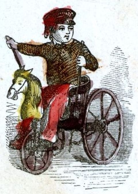 boy seated on tricycle which has a horse's head
